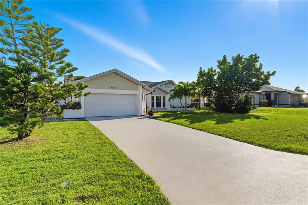 Ranch-style home with driveway, a front lawn, and an attached garage