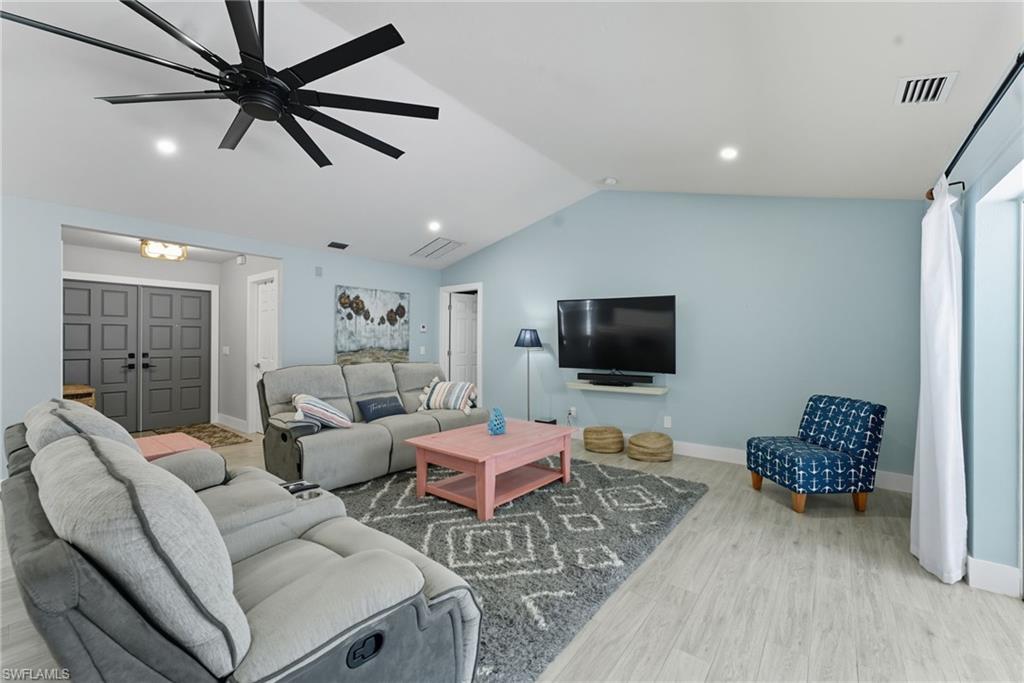 Living room featuring lofted ceiling, light wood finished floors, recessed lighting, and ceiling fan