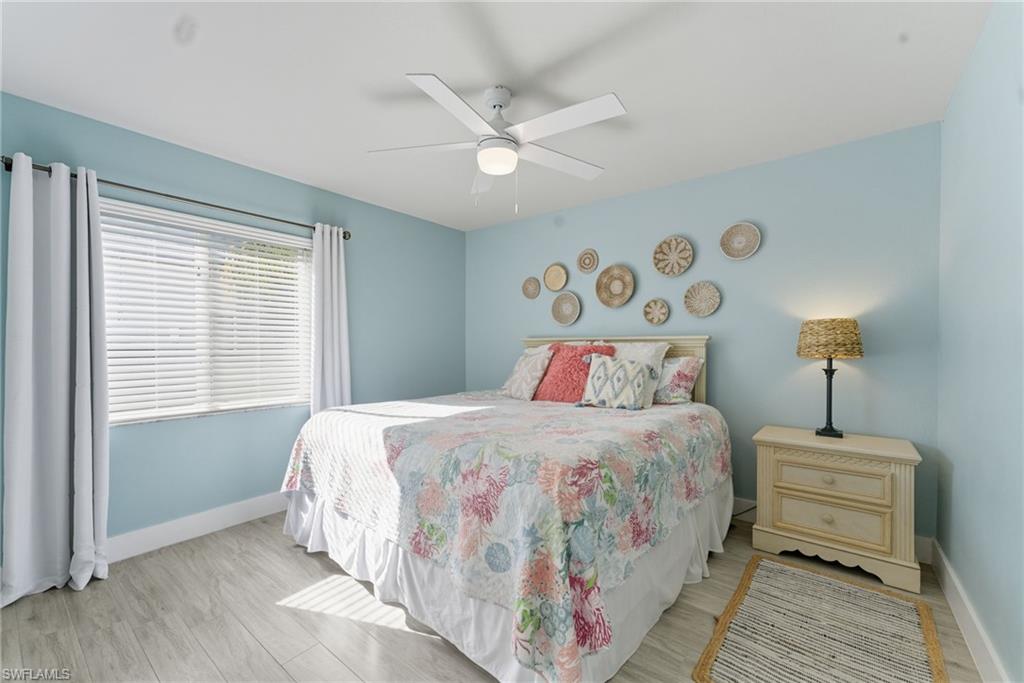 Bedroom with ceiling fan and light wood-style flooring