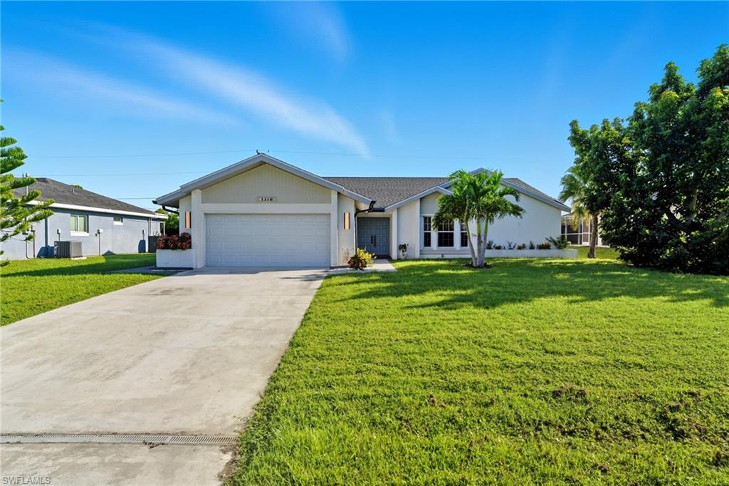 Ranch-style house with concrete driveway, a front lawn, and a garage