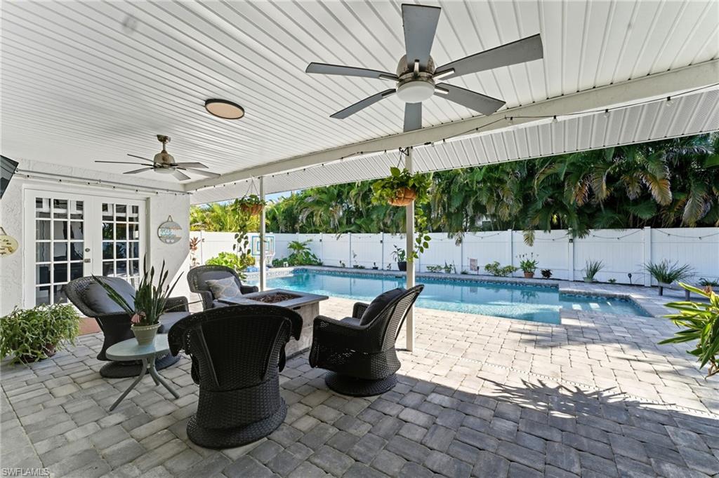 View of pool featuring ceiling fan, a patio, a fire pit, and french doors