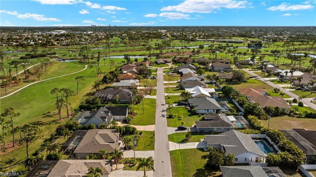 Aerial perspective of suburban area featuring a nearby body of water and a golf club