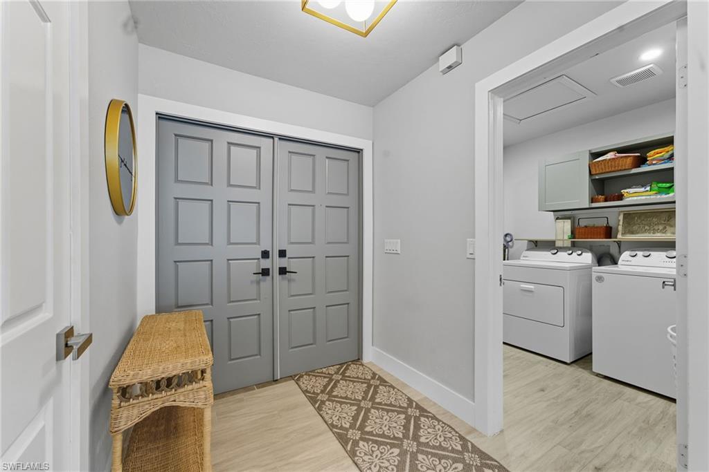Entrance foyer with washing machine and clothes dryer and light wood-style flooring