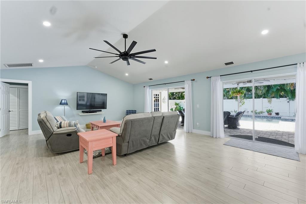 Living room featuring lofted ceiling, light wood-style flooring, recessed lighting, and a ceiling fan
