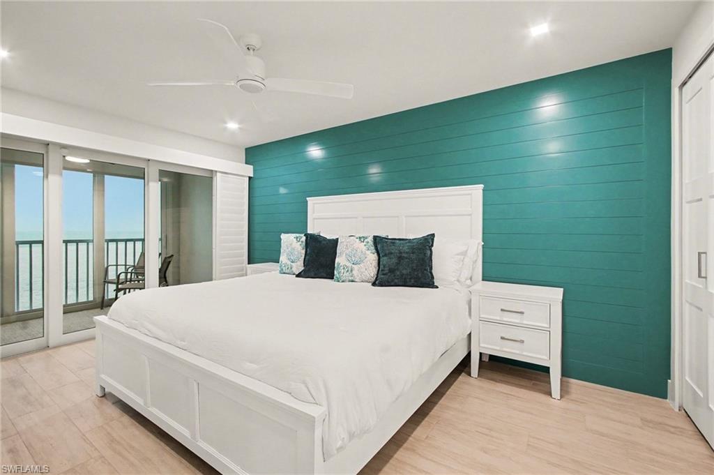 Interior space featuring a shiplap accent wall, light wood-finish flooring, and a ceiling fan with integrated lighting
