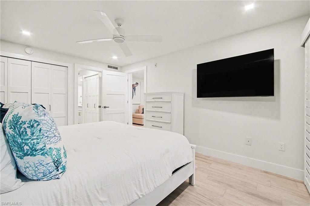Neutral-toned bedroom featuring wood-finish flooring and recessed lighting