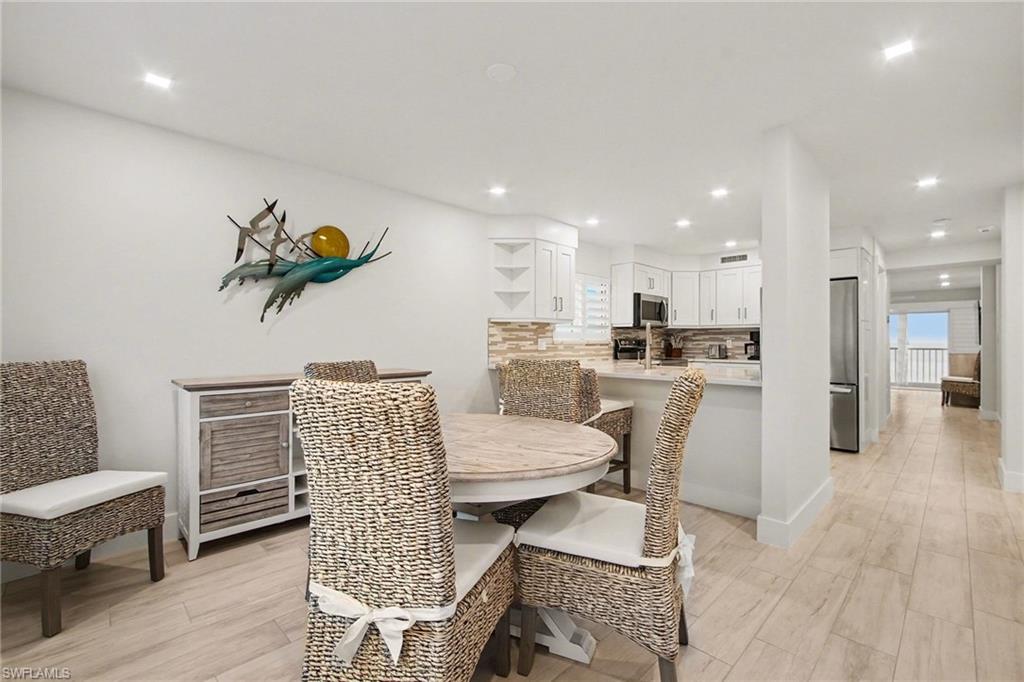 Open-concept dining area featuring light-toned wood-finish flooring