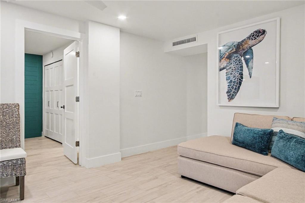 Recessed lighting illuminates the neutral-toned flooring