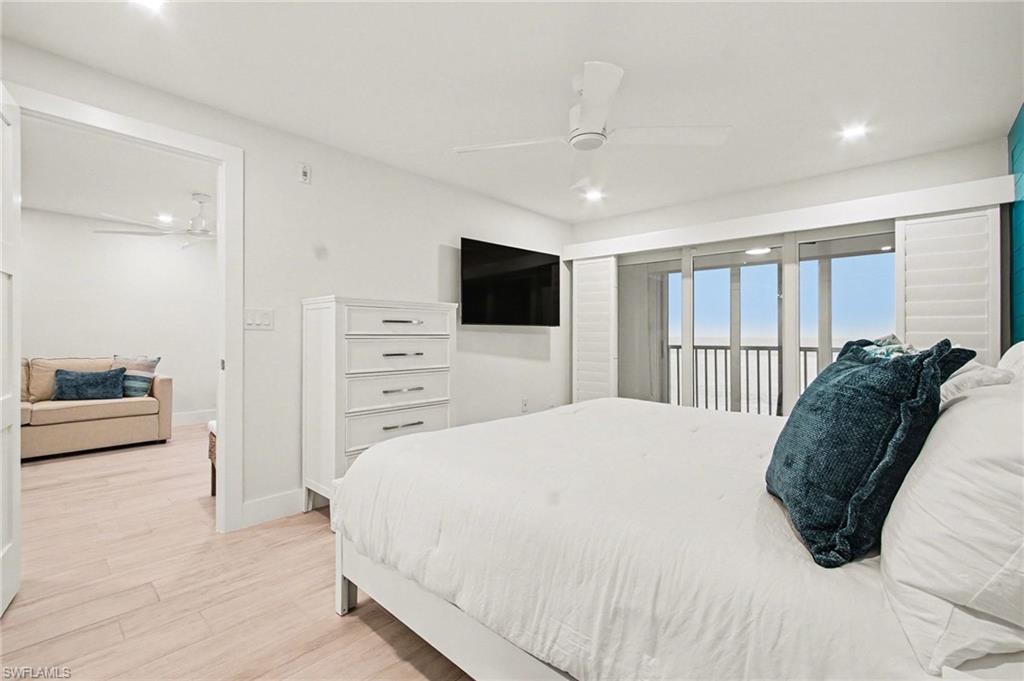 Bright bedroom featuring wood-finish flooring and a white ceiling fan