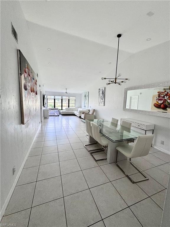 Dining space with light tile patterned floors and hanging lights
