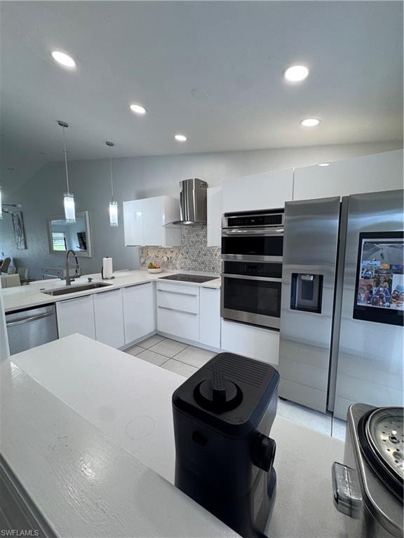 Kitchen featuring stainless steel appliances, white cabinets, pendant lighting, modern cabinets, and exhaust hood