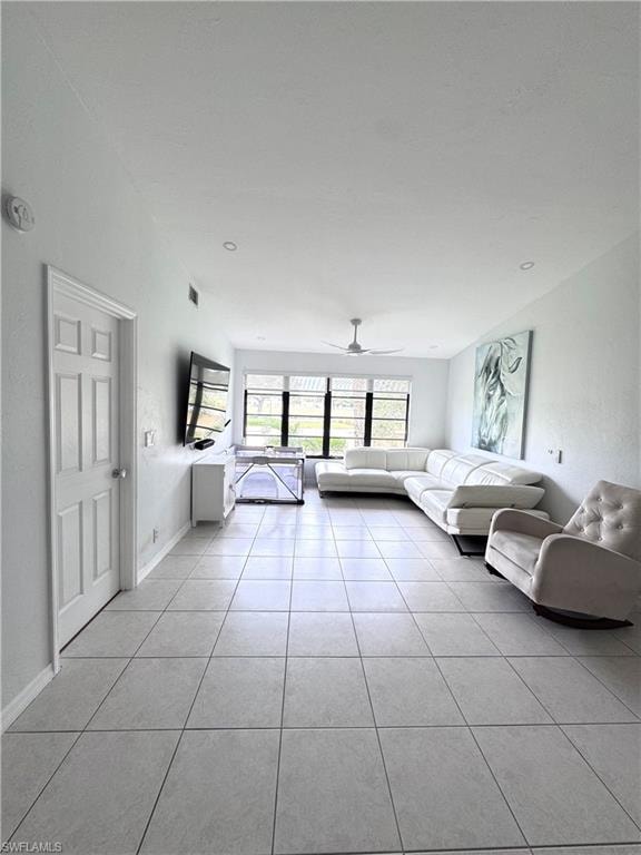 Living room with ceiling fan and light tile patterned floors