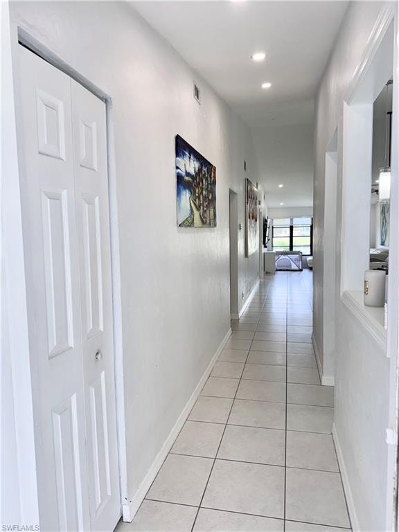 Hallway with light tile patterned flooring and recessed lighting