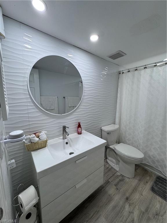 Bathroom with tile walls, vanity, a shower with curtain, wood finished floors, and recessed lighting