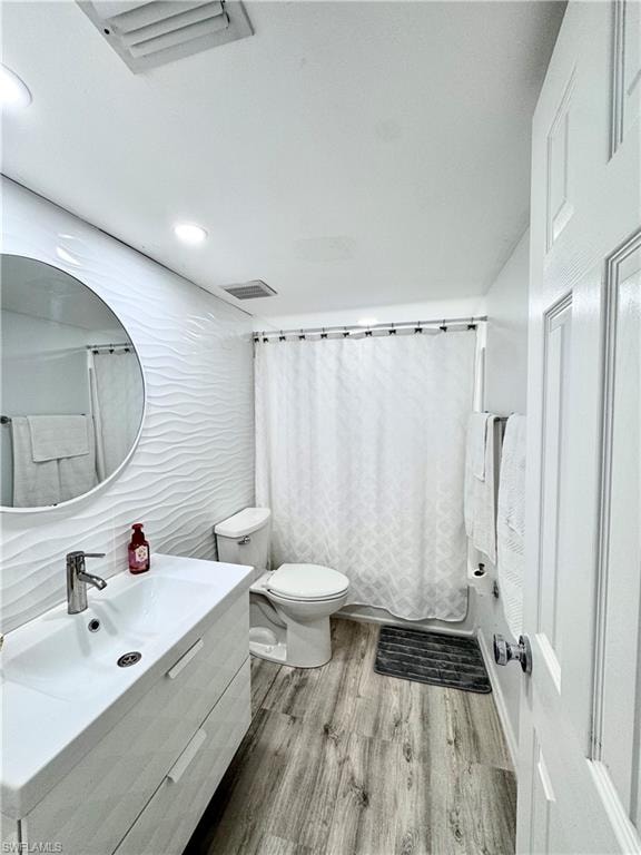 Bathroom featuring vanity, shower / tub combo, light wood-style flooring, recessed lighting, and tile walls