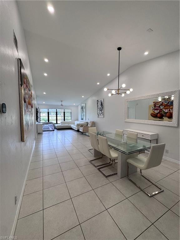 Dining area featuring light tile patterned floors, a chandelier, and vaulted ceiling