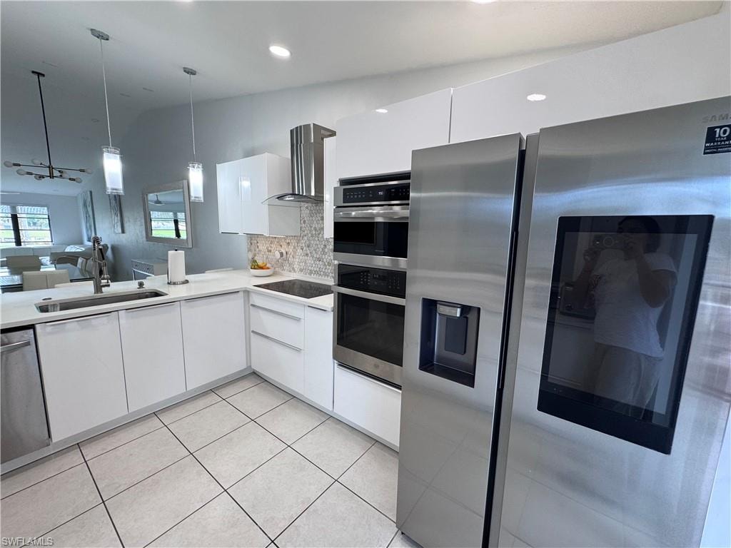 Kitchen featuring stainless steel appliances, white cabinets, open floor plan, tasteful backsplash, and modern cabinets