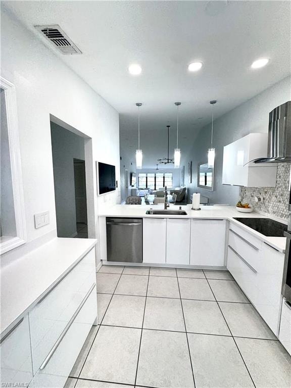 Kitchen with white cabinets, open floor plan, decorative light fixtures, and stainless steel dishwasher