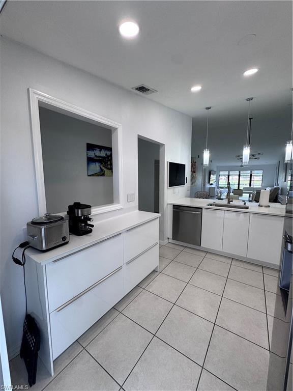 Kitchen with white cabinetry, modern cabinets, hanging light fixtures, open floor plan, and dishwashing machine