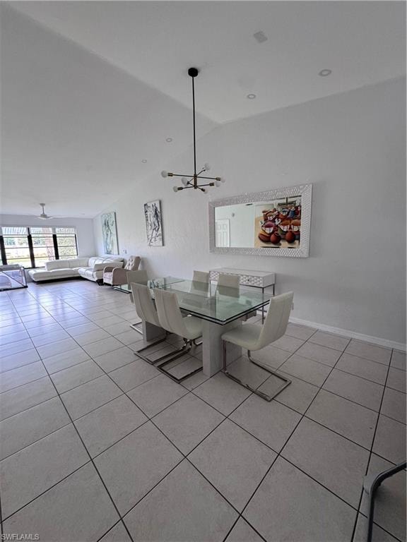 Dining space featuring light tile patterned floors, lofted ceiling, and hanging lights