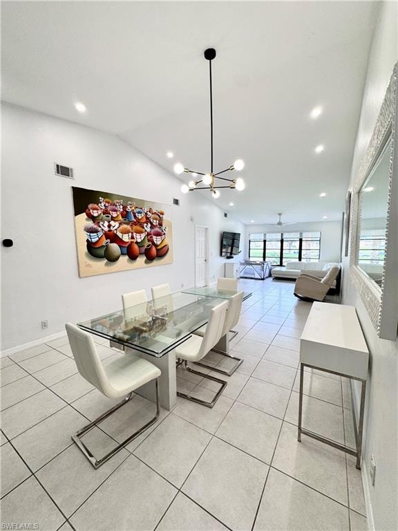 Dining space with light tile patterned floors, lofted ceiling, suspended lighting, and ceiling fan