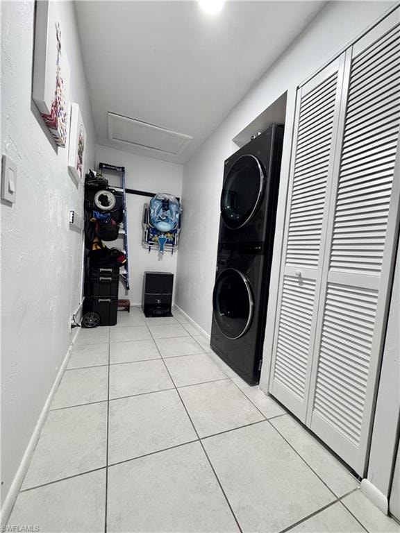 Laundry area with stacked washer / dryer and light tile patterned floors