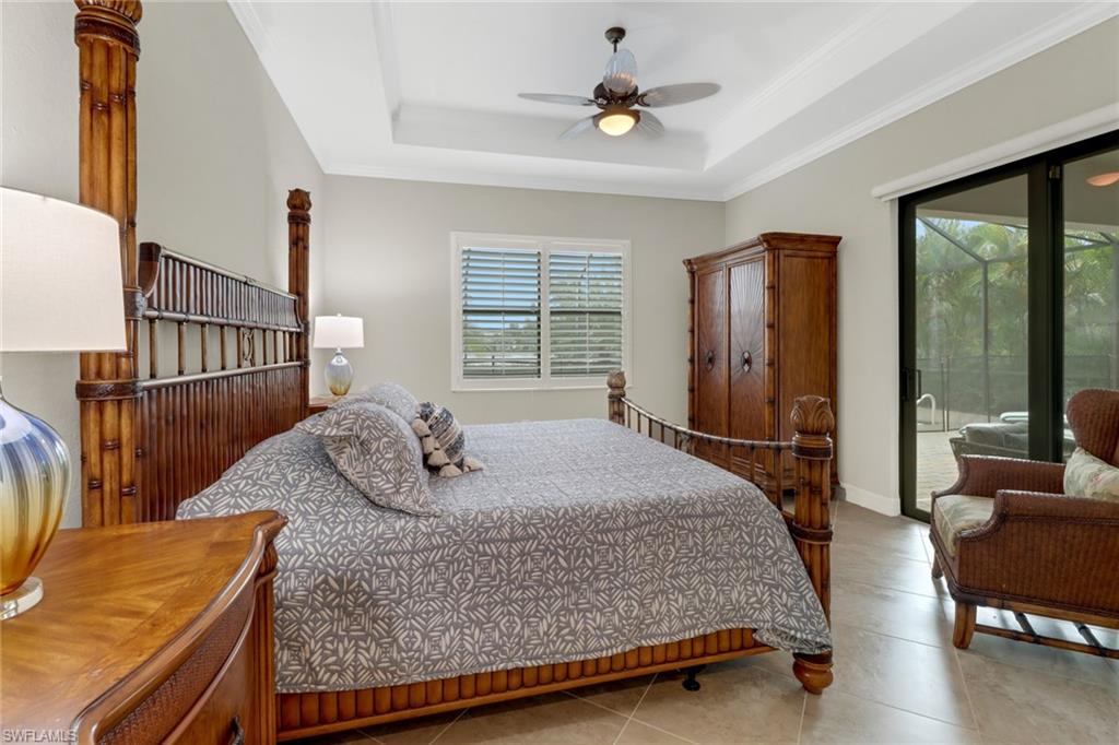 Beautiful primary bedroom with sliding glass door leading to the covered lanai area