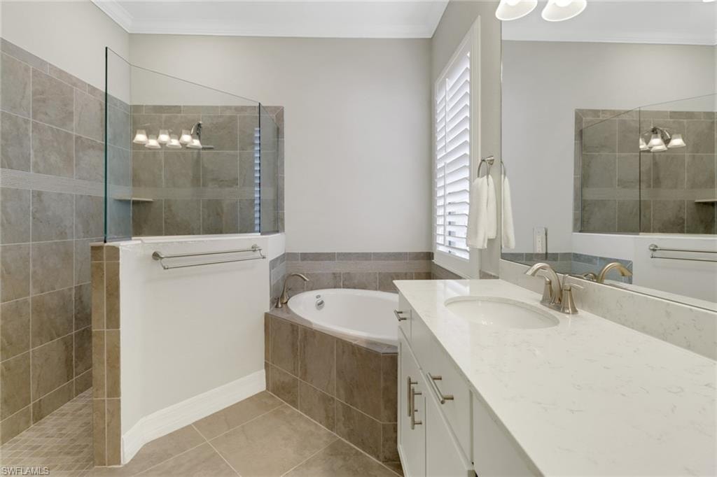 Luxurious primary bathroom featuring vanity with dual sinks, soaking tub & large tiled shower