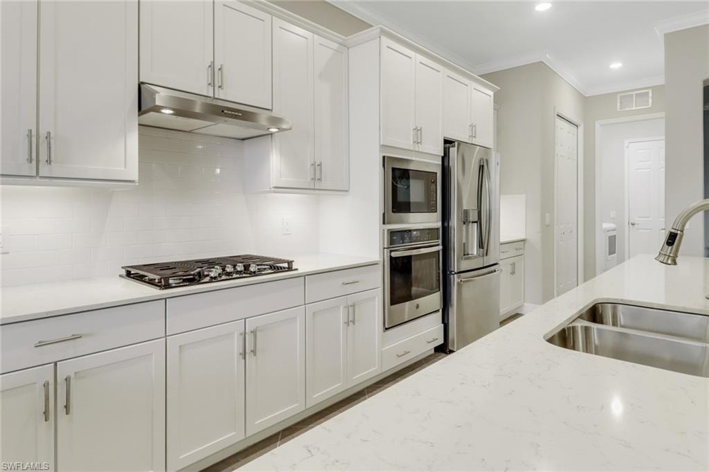 Kitchen with gas cooktop, upgraded white shaker cabinetry, stainless steel appliances & large pantry