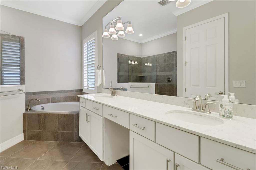 Luxurious primary bathroom featuring vanity with dual sinks, soaking tub & large tiled shower