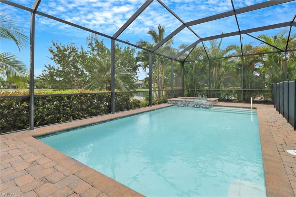 Sparkling swimming pool & spa on the screened lanai overlooking mature landscaping