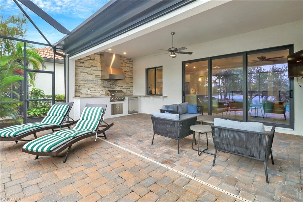 Patio with a covered area, outdoor kitchen, grill, lounge area, and ceiling fan