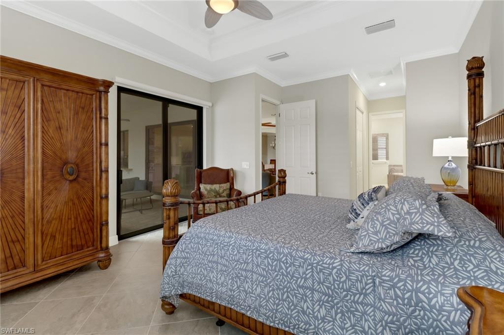 Beautiful primary bedroom with sliding glass door leading to the covered lanai area