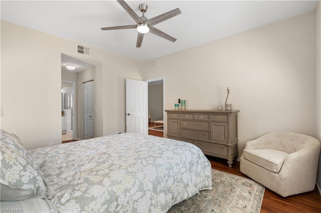 Bedroom featuring wood finished floors, visible vents, a closet, and ceiling fan