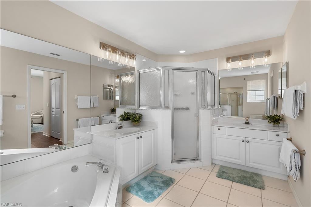 Bathroom with a shower stall, two vanities, and a sink