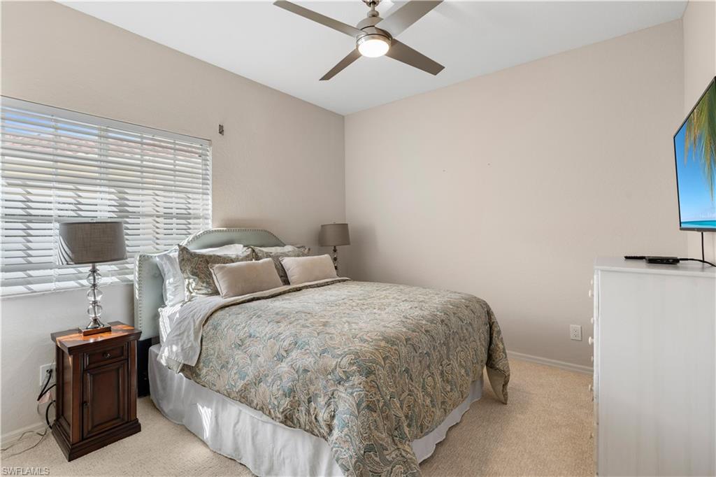 Bedroom featuring baseboards, light colored carpet, and ceiling fan