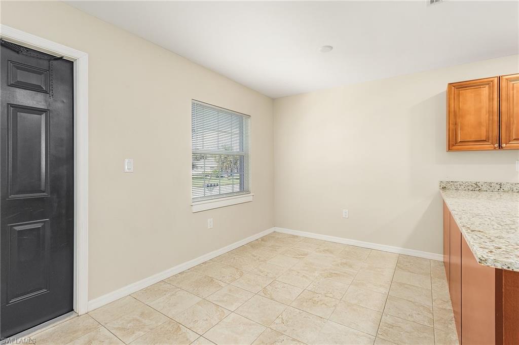 Unfurnished dining area featuring baseboards and light tile patterned flooring