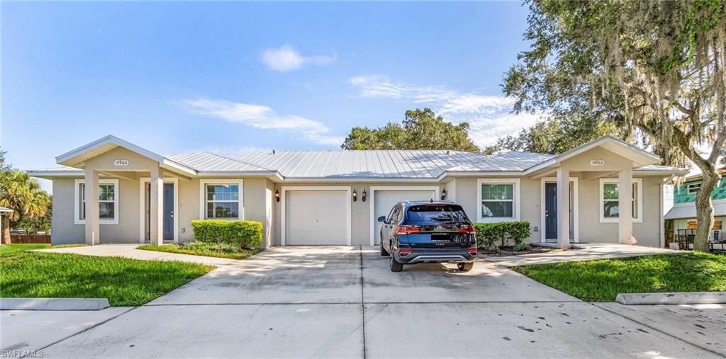 Ranch-style home featuring stucco siding, driveway, and a front lawn