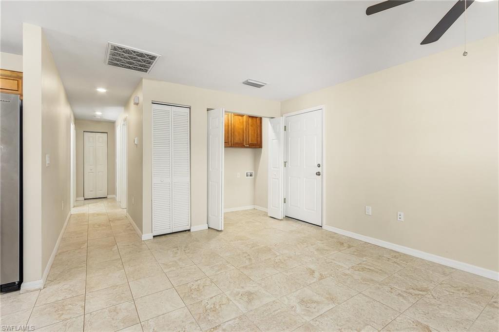 Unfurnished bedroom with freestanding refrigerator, ceiling fan, recessed lighting, and multiple closets