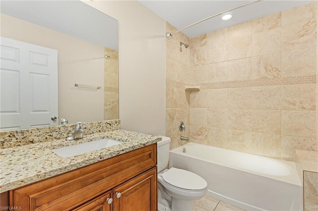 Bathroom with shower / bathtub combination, vanity, light tile patterned flooring, and recessed lighting