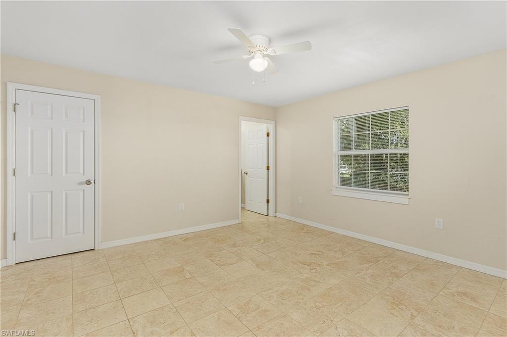 Empty room with baseboards and a ceiling fan