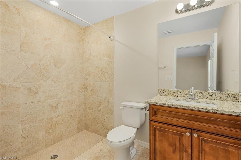 Bathroom featuring vanity, a shower stall, and light tile patterned floors