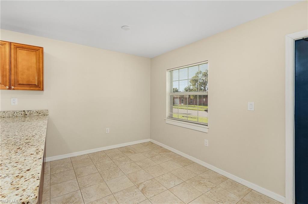 Unfurnished dining area featuring baseboards and light tile patterned floors