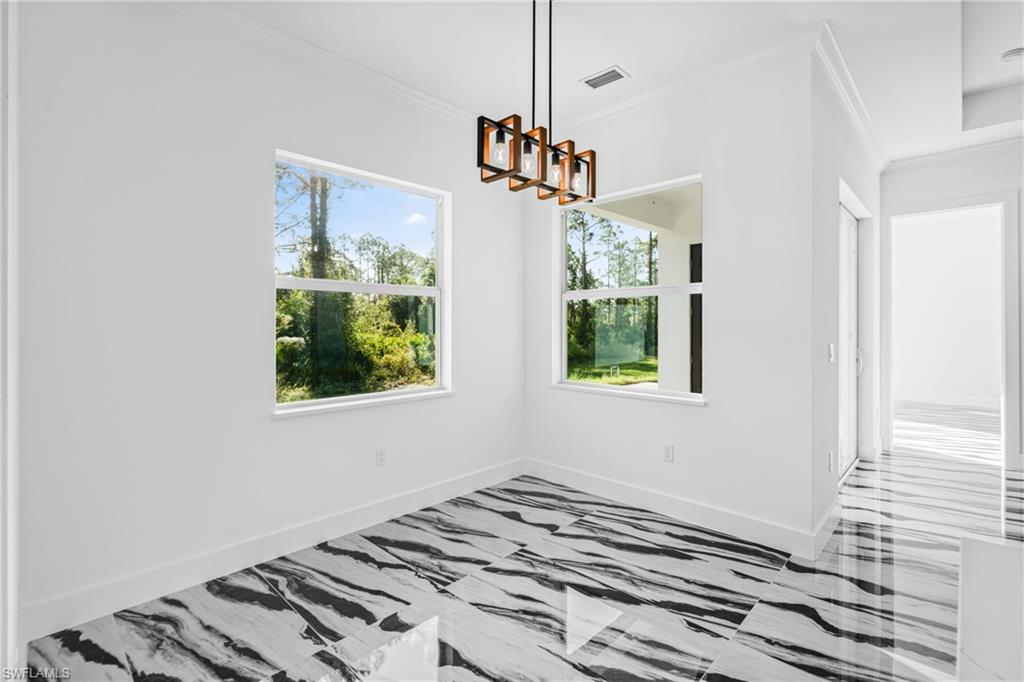 Unfurnished dining area with ornamental molding and a chandelier