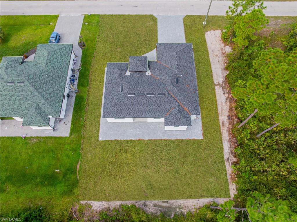 Rear view of property with a lawn and stucco siding