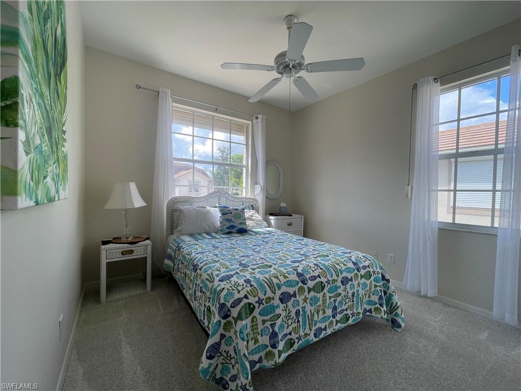 Carpeted bedroom featuring ceiling fan and baseboards