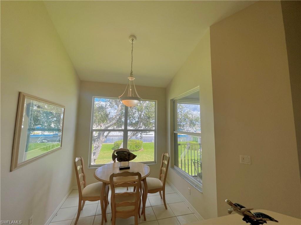 Dining room with light tile patterned flooring and lofted ceiling