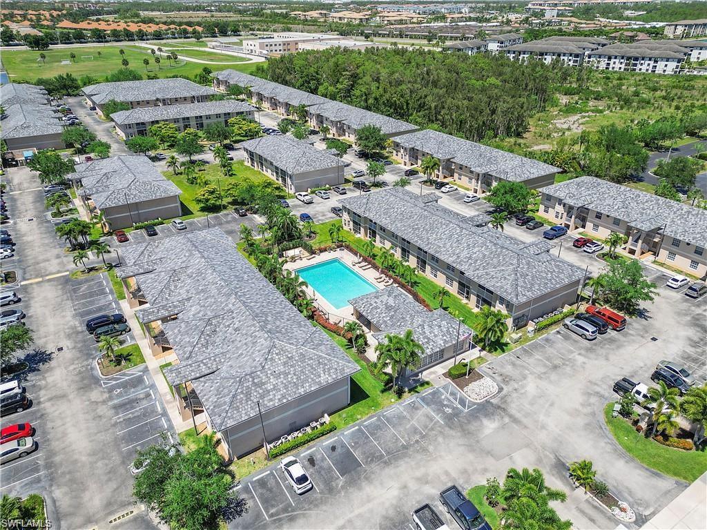 Drone / aerial view of a pool area and apartment complex