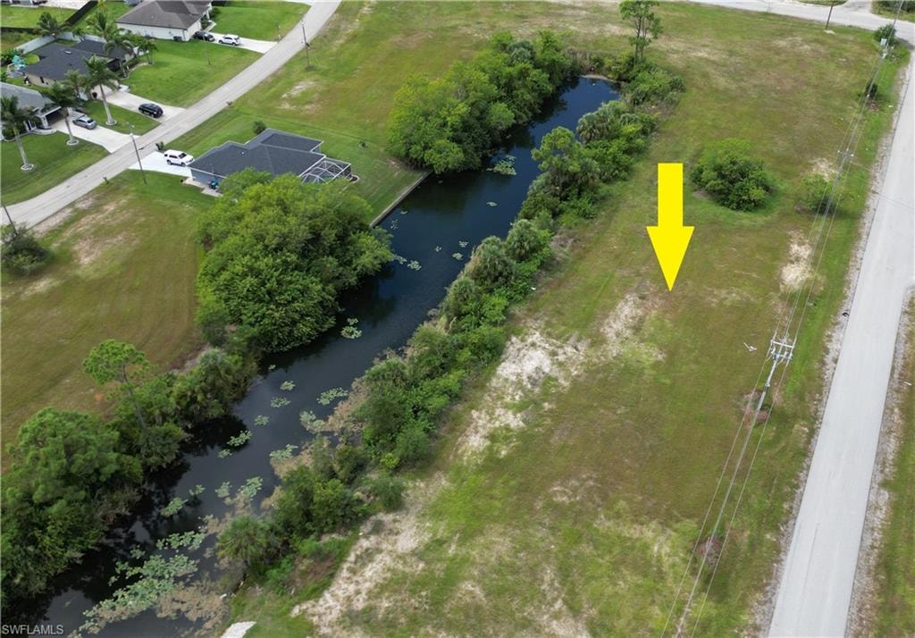Aerial view of property and surrounding area with a nearby body of water