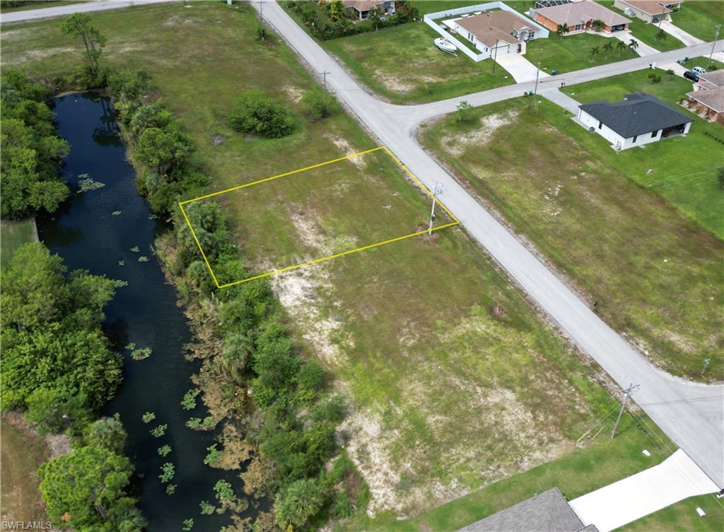 Aerial view of property and surrounding area with a large body of water and property boundaries highlighted